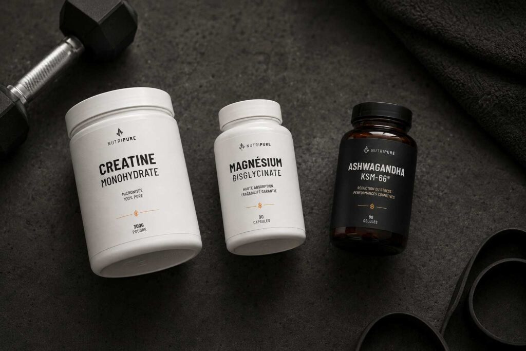 Stack suppléments musculation maison — créatine monohydrate, magnésium bisglycinate et ashwagandha KSM-66 alignés sur fond béton anthracite